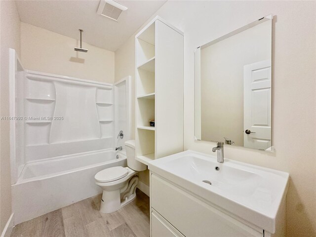 full bathroom with vanity, toilet, hardwood / wood-style flooring, and bathing tub / shower combination