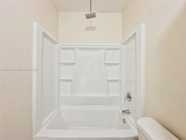 bathroom featuring shower / washtub combination and toilet