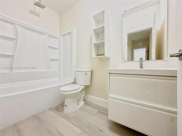 full bathroom featuring vanity, toilet, hardwood / wood-style flooring, and shower / tub combination