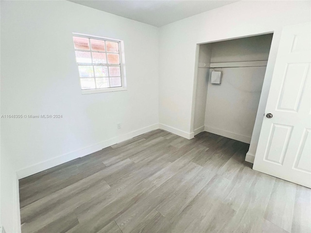 unfurnished bedroom featuring light hardwood / wood-style floors and a closet