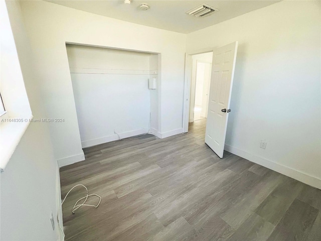 unfurnished bedroom featuring hardwood / wood-style floors and a closet