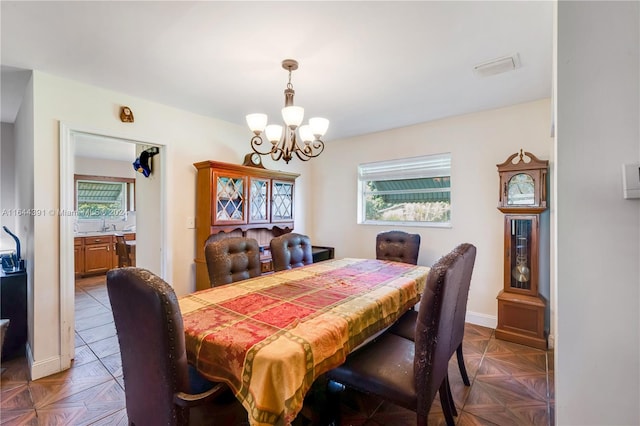 dining room featuring dark parquet floors and an inviting chandelier