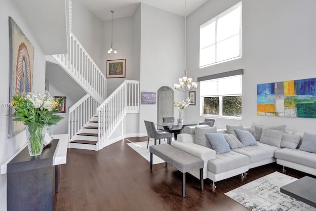 living room featuring a high ceiling, dark hardwood / wood-style floors, and a chandelier