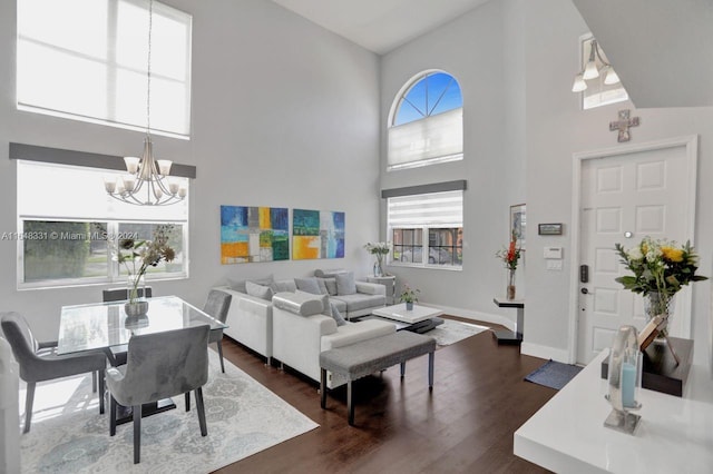 living room with high vaulted ceiling, a wealth of natural light, a chandelier, and dark hardwood / wood-style floors