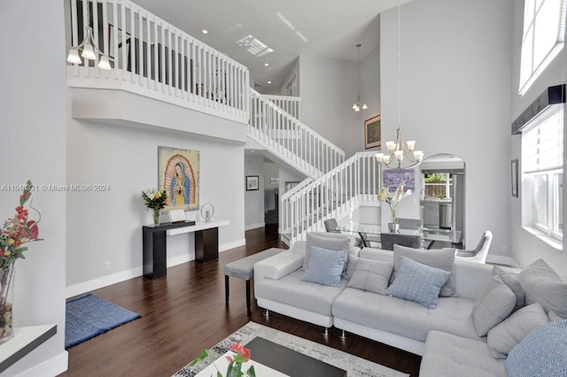 living room featuring dark hardwood / wood-style floors, a notable chandelier, and a towering ceiling