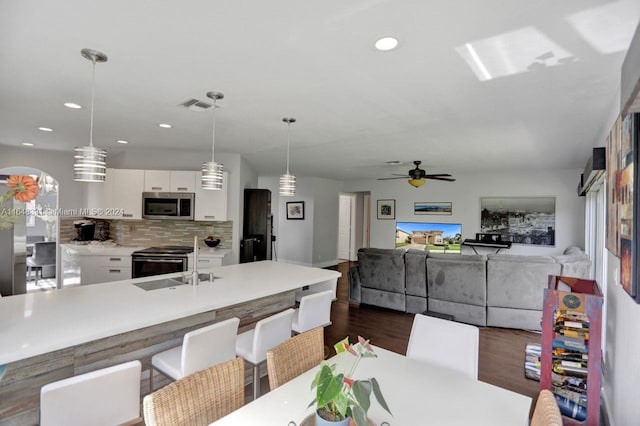 dining area with dark wood-type flooring, sink, and ceiling fan