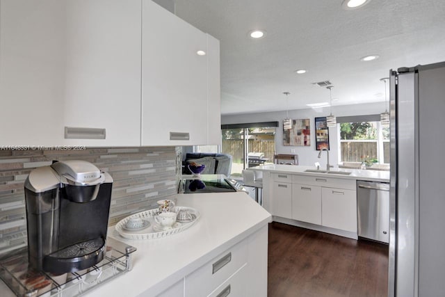 kitchen featuring white cabinetry, a textured ceiling, sink, dark hardwood / wood-style floors, and stainless steel dishwasher