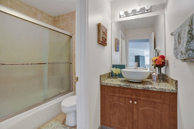 full bathroom featuring vanity, toilet, tile patterned floors, and enclosed tub / shower combo