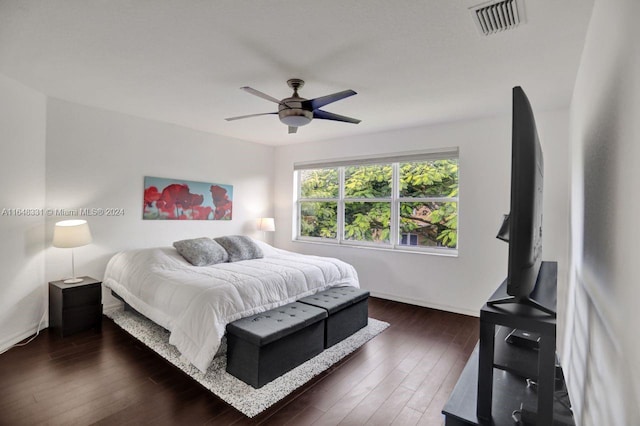 bedroom with dark hardwood / wood-style flooring and ceiling fan