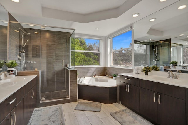 bathroom featuring vanity, a tray ceiling, and plus walk in shower