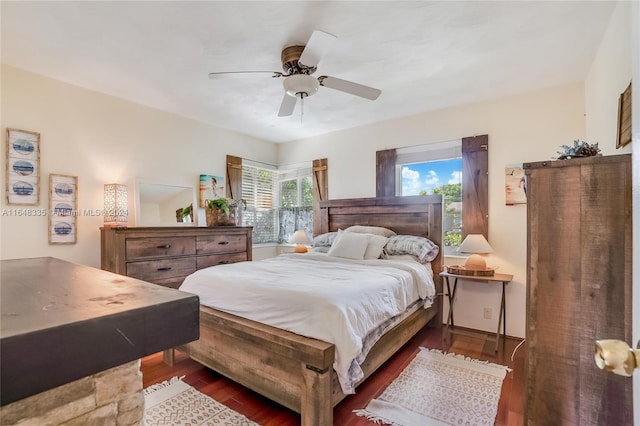 bedroom with dark hardwood / wood-style flooring and ceiling fan