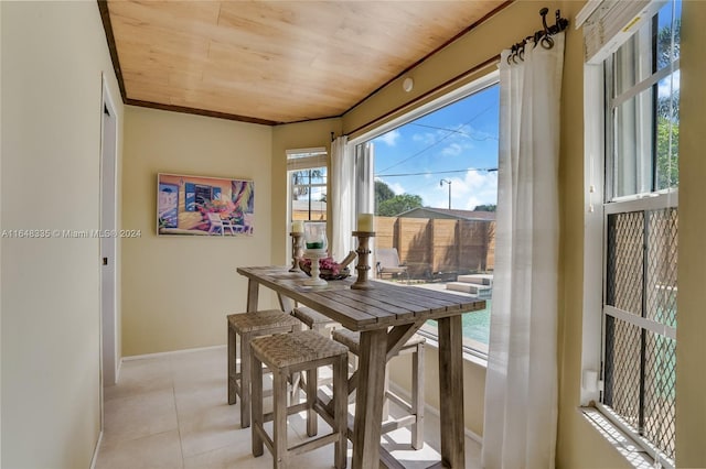 dining room featuring light tile patterned flooring, wood ceiling, and baseboards