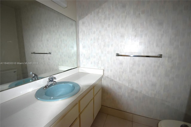 bathroom with toilet, vanity, and tile patterned floors