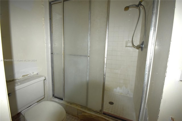 bathroom featuring toilet and a stall shower