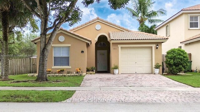 mediterranean / spanish home with a garage and a front yard