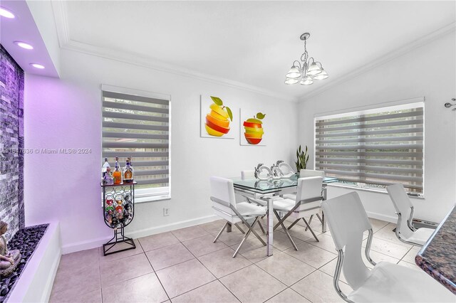 tiled dining area with vaulted ceiling, an inviting chandelier, and ornamental molding