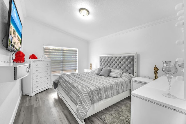 bedroom with lofted ceiling, ornamental molding, and hardwood / wood-style flooring