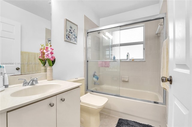 full bathroom with vanity, toilet, bath / shower combo with glass door, and tile patterned floors