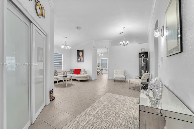 living room with crown molding, a notable chandelier, and light tile patterned flooring