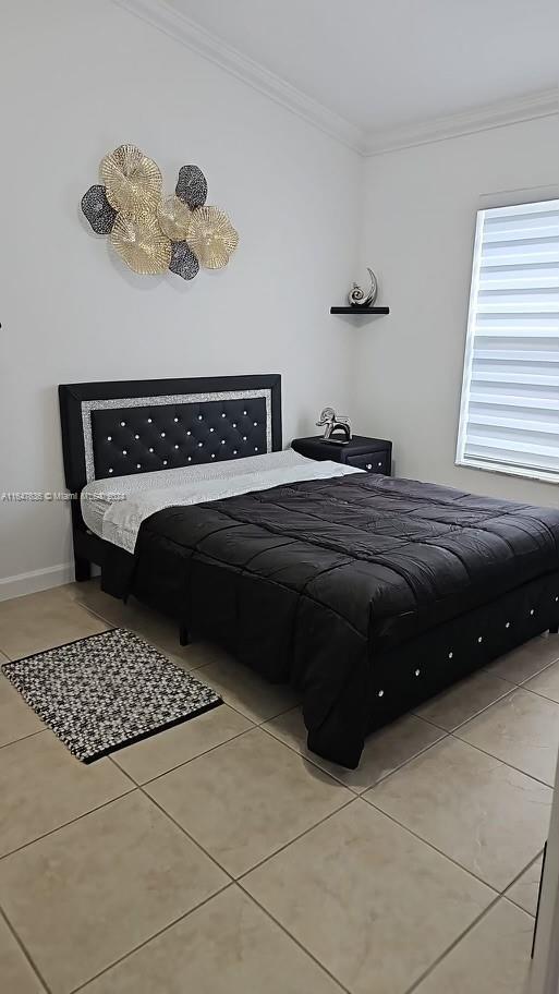 bedroom with crown molding and light tile patterned flooring