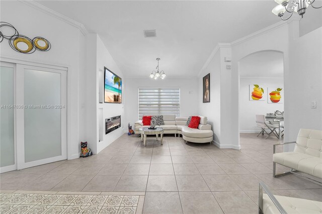 living room featuring crown molding, light tile patterned floors, and a notable chandelier