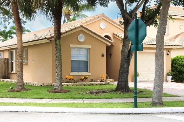 view of front of house with a garage and a front lawn