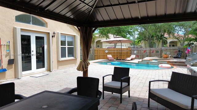 view of swimming pool featuring an in ground hot tub, french doors, and a patio