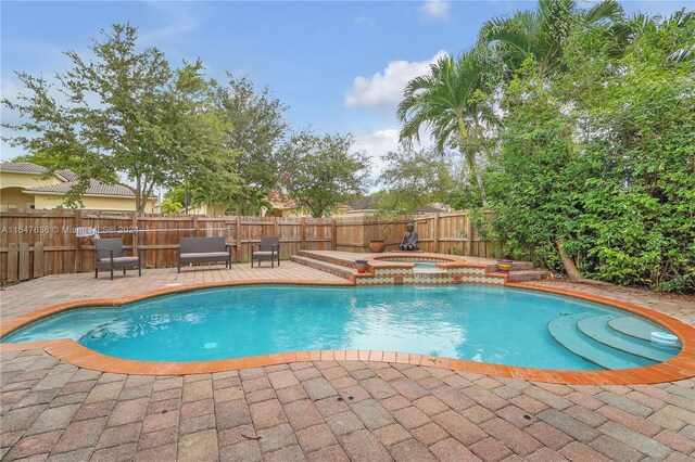 view of swimming pool with an in ground hot tub and a patio area