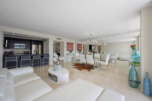 tiled living room featuring a notable chandelier and visible vents
