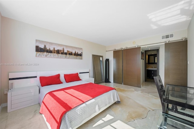 bedroom with a barn door and visible vents