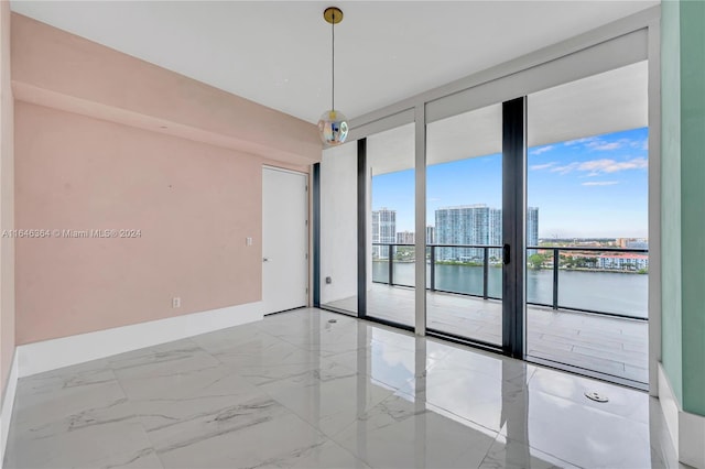 empty room featuring expansive windows and a water view