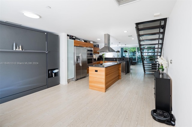 kitchen featuring dark countertops, visible vents, light wood finished floors, stainless steel refrigerator with ice dispenser, and island range hood