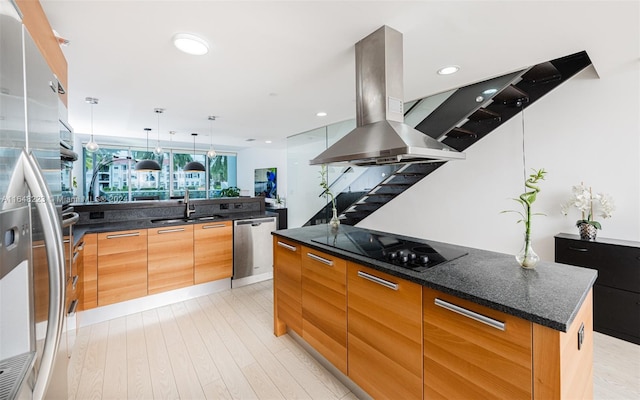 kitchen with stainless steel appliances, a spacious island, sink, light wood-type flooring, and island exhaust hood