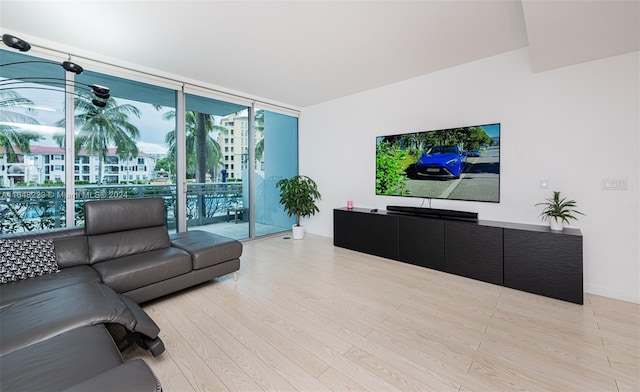 living room featuring a wall of windows and light hardwood / wood-style flooring