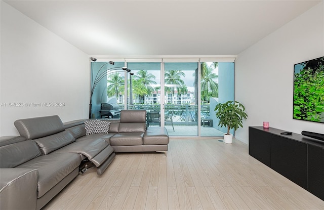 living room with light wood-type flooring and a wall of windows