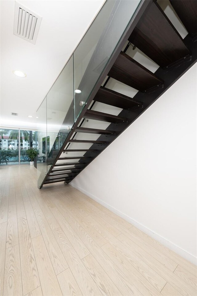 stairs with hardwood / wood-style floors and a wall of windows