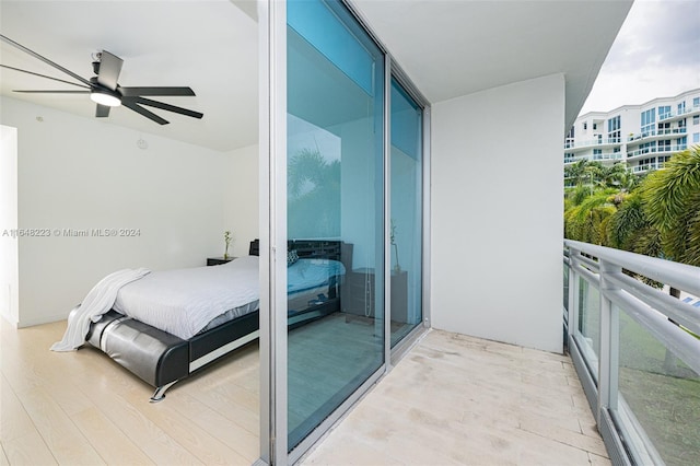 bedroom featuring expansive windows, ceiling fan, and light wood-type flooring