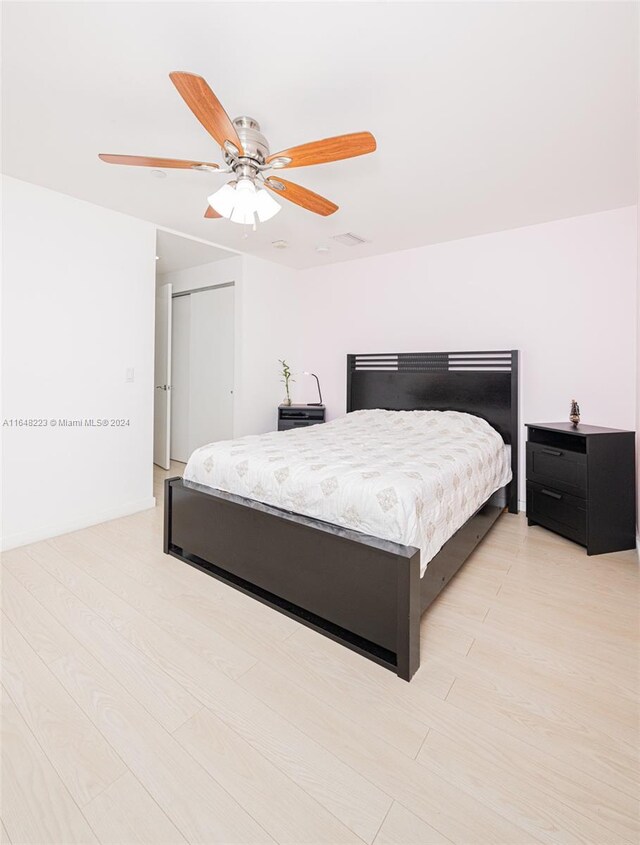 bedroom with ceiling fan, light wood-type flooring, and a closet