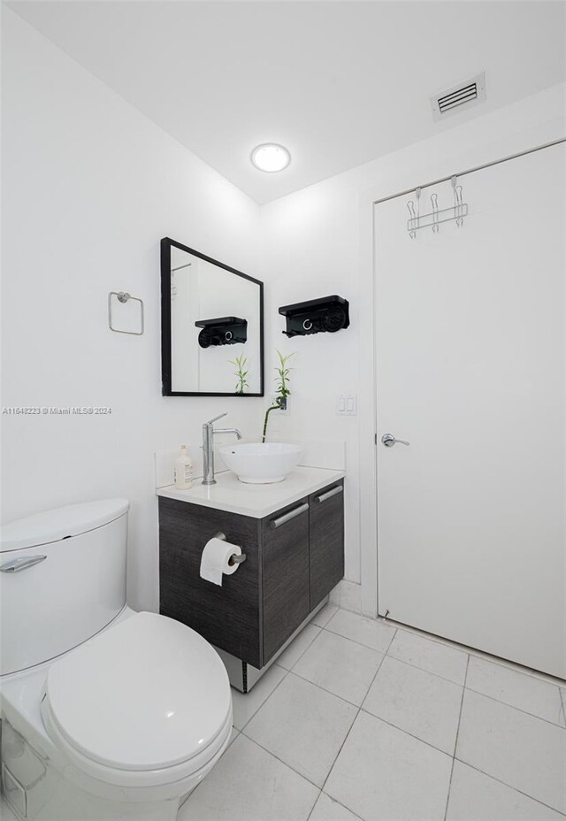 bathroom featuring toilet, vanity, and tile patterned floors