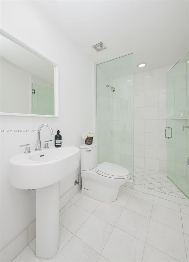 bathroom featuring tile patterned flooring, an enclosed shower, and toilet