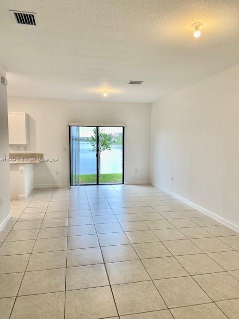 unfurnished room featuring light tile patterned floors and a textured ceiling