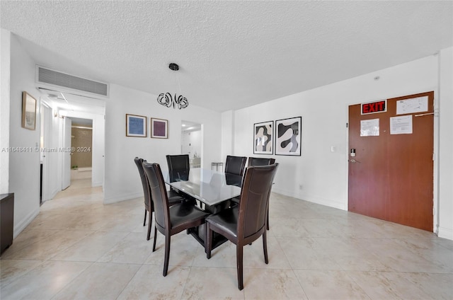 dining space featuring a textured ceiling and a notable chandelier