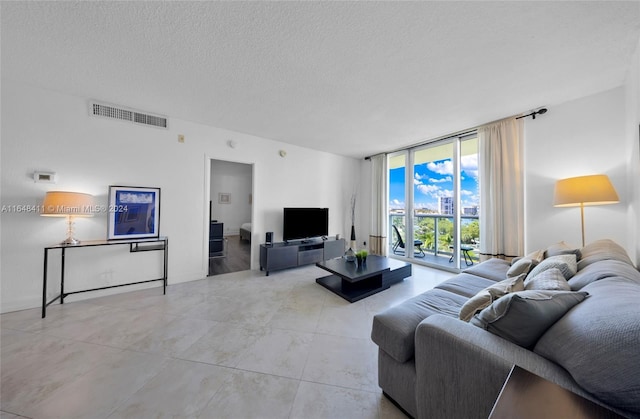 living room with floor to ceiling windows and a textured ceiling