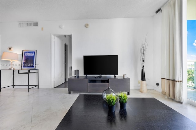 living room featuring light tile patterned floors and a textured ceiling