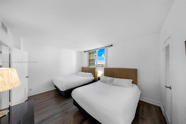 bedroom with dark hardwood / wood-style flooring