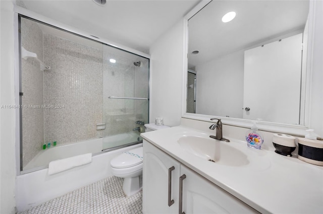 full bathroom with shower / bath combination with glass door, vanity, tile patterned floors, and toilet