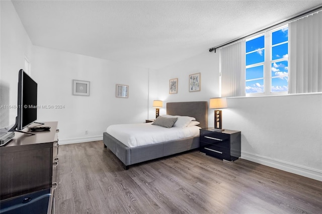 bedroom featuring wood-type flooring and a textured ceiling