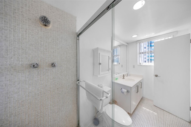 bathroom featuring toilet, vanity, tiled shower, and tile patterned floors