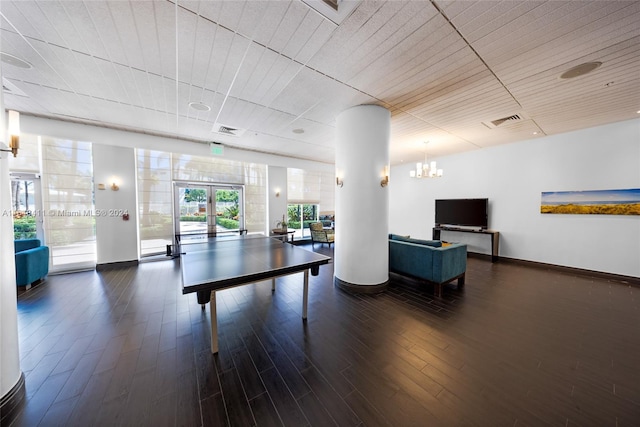 interior space with a notable chandelier, dark hardwood / wood-style flooring, and french doors