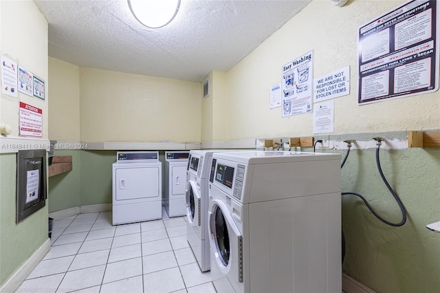 washroom with light tile patterned floors, a textured ceiling, and independent washer and dryer